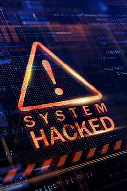 A black computer screen filled with dark blue code and a large red and orange “system hacked” image in the middle.